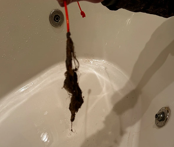 Person cleaning the bathtub, showcasing effective cleaning techniques for a sparkling bathroom.
