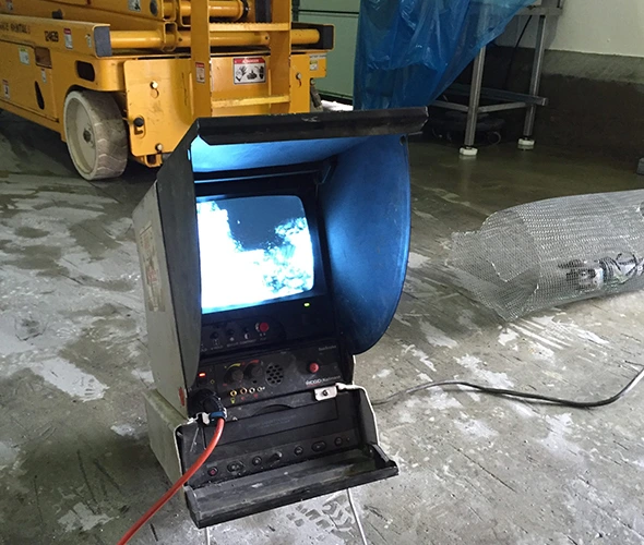 Computer monitor on the floor in a room, showcasing video inspection and line locating services for efficient diagnostics.