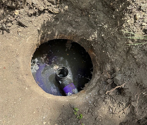 A Pipe placed in a hole, highlighting the need for effective frozen sewer line repair services.