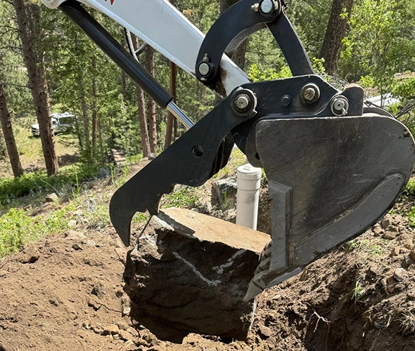 Backhoe at work in the ground, emphasizing professional main sewer line repair services.